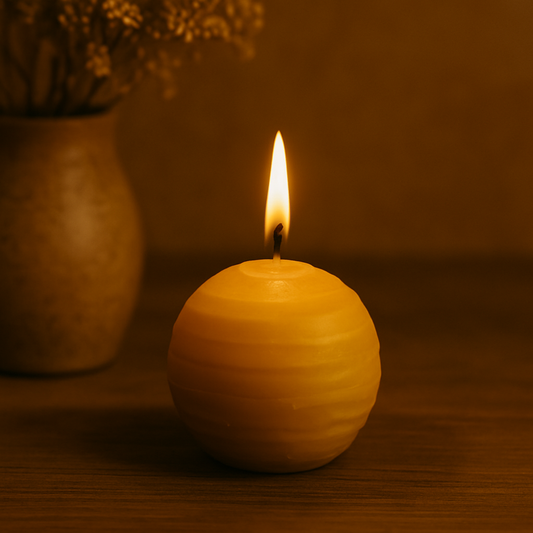 Bougie boule en cire d'abeille allumée sur fond chaleureux