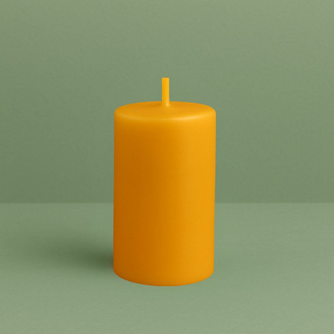 Bougie cylindrique lisse en cire d’abeille naturelle, de couleur jaune dorée, avec une mèche en cire assortie. Posée sur un fond vert doux, au design simple, artisanal et épuré.