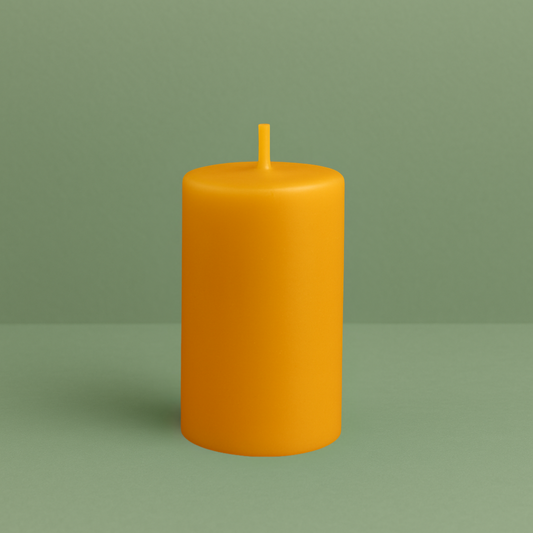 Bougie cylindrique lisse en cire d’abeille naturelle, de couleur jaune dorée, avec une mèche en cire assortie. Posée sur un fond vert doux, au design simple, artisanal et épuré.