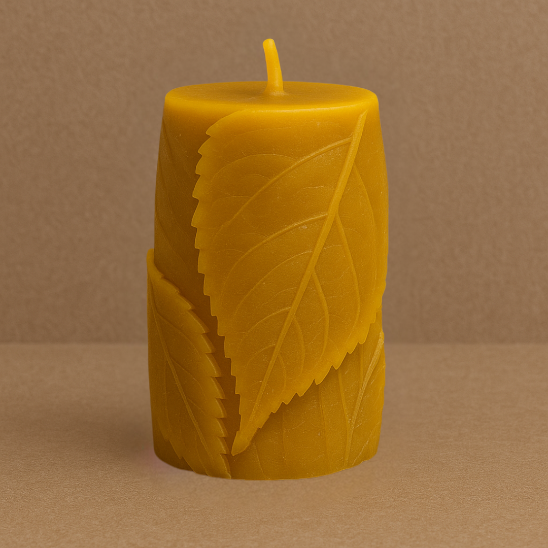 Bougie en cire d’abeille naturelle, sculptée avec des motifs de feuilles en relief, posée sur un fond marron uni. Format épais, idéale pour une combustion longue durée.