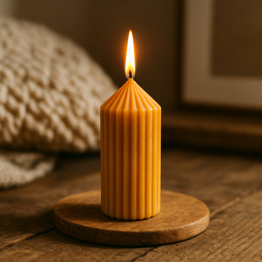 Bougie pilier L en cire d’abeille allumée, posée sur un support en bois dans un décor chaleureux avec coussin en tricot crème et fond naturel, ambiance artisanale et cosy.