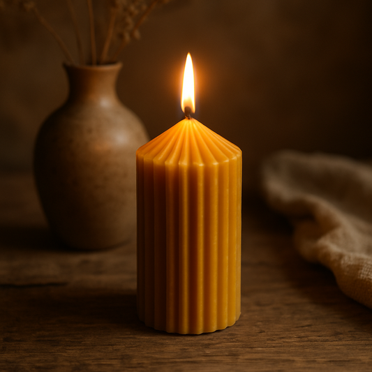  Bougie pilier XL en cire d'abeille naturelle allumée, posée sur une table en bois brut avec un vase artisanal en arrière-plan, ambiance chaleureuse et authentique.