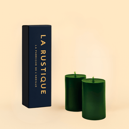 Deux bougies cylindriques vert foncé La Rustique en cire d’abeille naturelle, accompagnées de leur étui raffiné bleu nuit signé La Fabrique de l’Abeille

