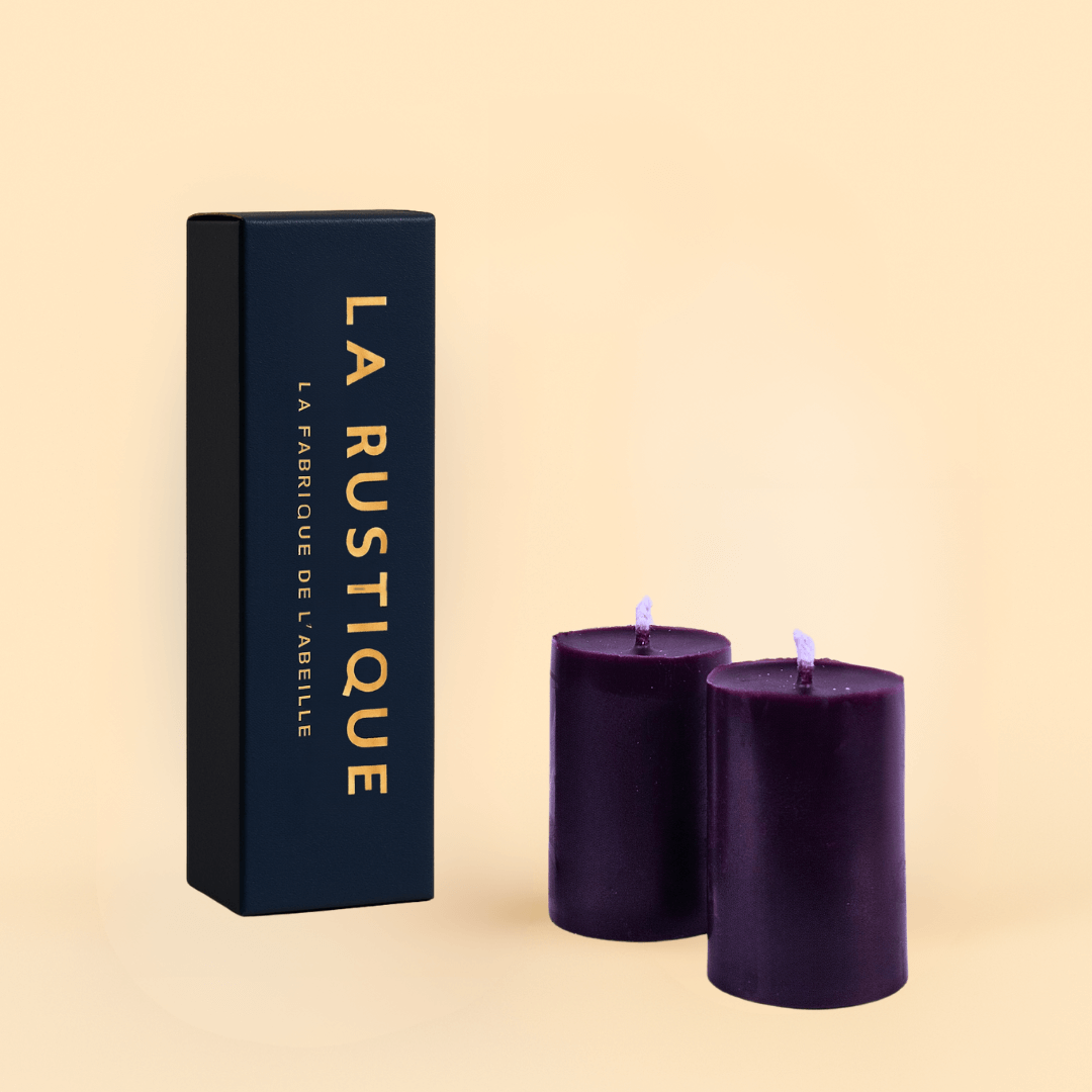 Deux bougies cylindriques violettes La Rustique en cire d’abeille naturelle, accompagnées de leur étui bleu nuit signé La Fabrique de l’Abeille