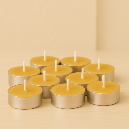 Lot de bougies chauffe-plat en cire d’abeille naturelle, de couleur jaune miel, avec mèches blanches dans des contenants en aluminium, disposées sur une surface en bois clair.